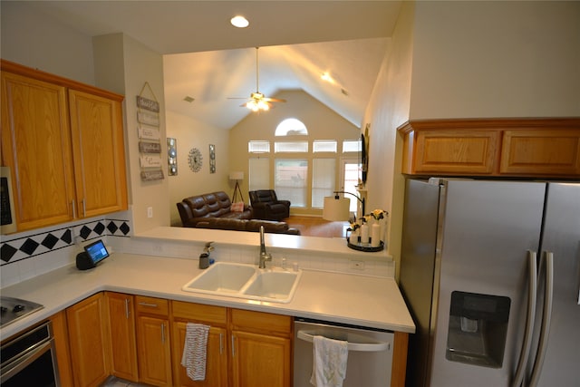 kitchen with appliances with stainless steel finishes, kitchen peninsula, lofted ceiling, ceiling fan, and sink