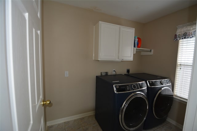 washroom with washer and clothes dryer, light tile patterned floors, and cabinets