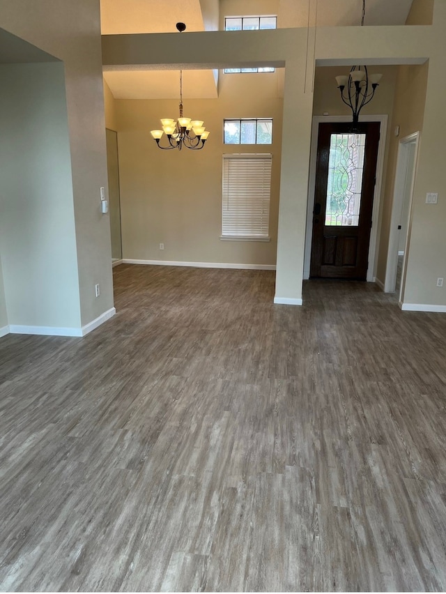 entrance foyer featuring an inviting chandelier, hardwood / wood-style flooring, and a towering ceiling