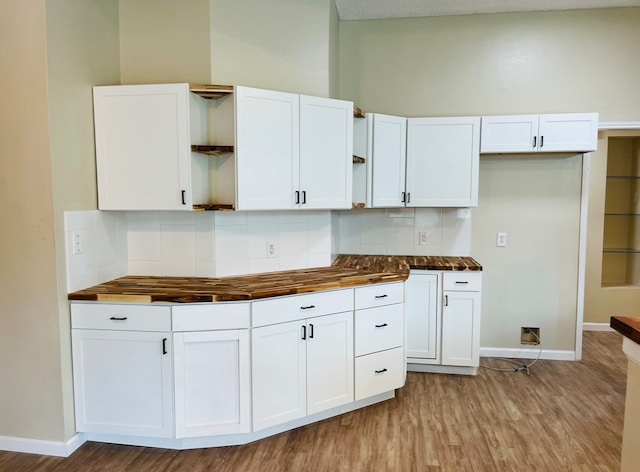 kitchen with white cabinets, backsplash, light hardwood / wood-style floors, and wood counters