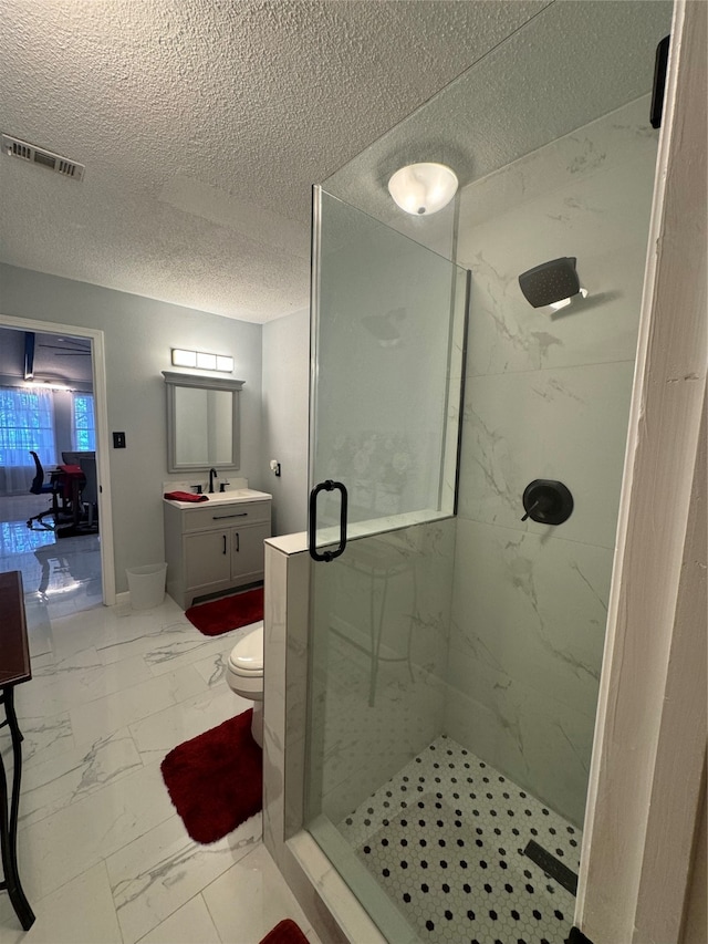 bathroom with vanity, toilet, and a shower with door