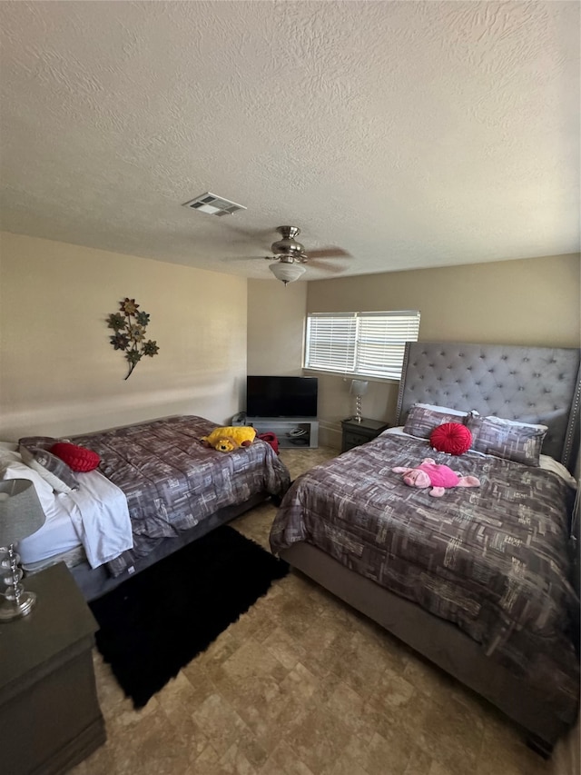 bedroom with a textured ceiling and ceiling fan