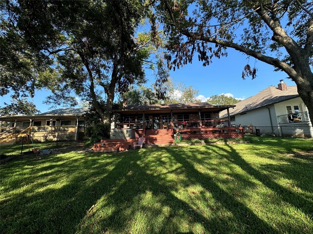 323 Mallard Pt, Livingston, TX 77351 - back of property featuring a deck, fence, and a lawn