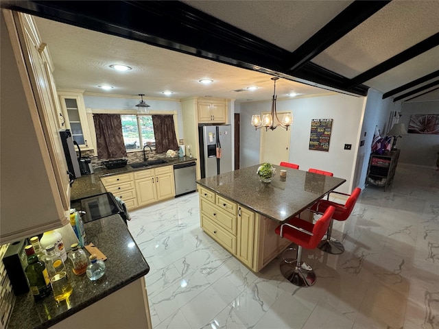 323 Mallard Pt, Livingston, TX 77351 - kitchen with a breakfast bar, recessed lighting, cream cabinetry, appliances with stainless steel finishes, and marble finish floor
