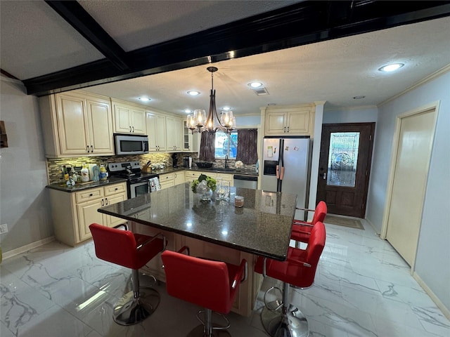 323 Mallard Pt, Livingston, TX 77351 - kitchen with baseboards, ornamental molding, cream cabinetry, appliances with stainless steel finishes, and marble finish floor