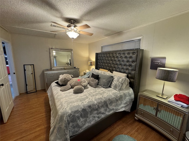 bedroom with a textured ceiling, ceiling fan, and dark wood-type flooring