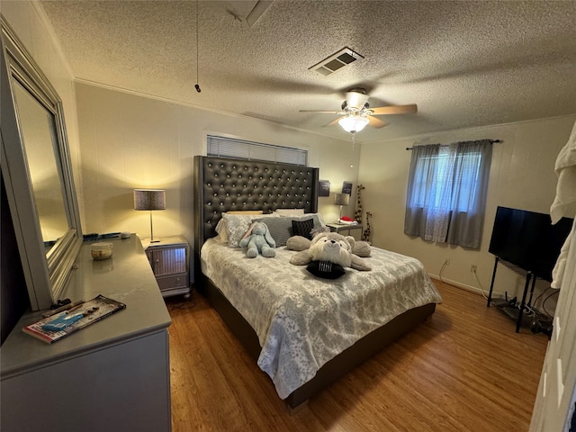 bedroom with a textured ceiling, dark hardwood / wood-style flooring, and ceiling fan