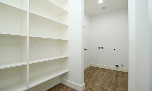 washroom featuring electric dryer hookup, gas dryer hookup, hookup for a washing machine, and dark wood-type flooring