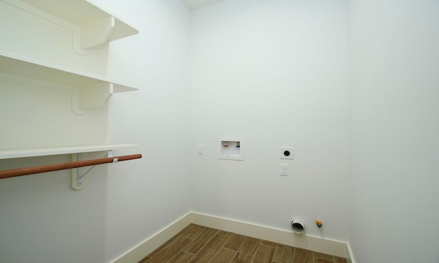 laundry room featuring electric dryer hookup, hookup for a washing machine, and hardwood / wood-style flooring