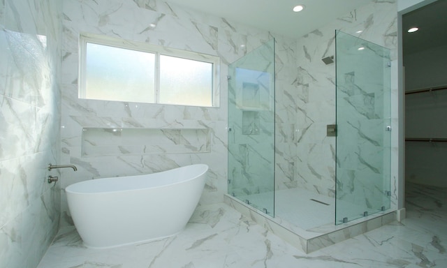 bathroom featuring shower with separate bathtub and tile walls