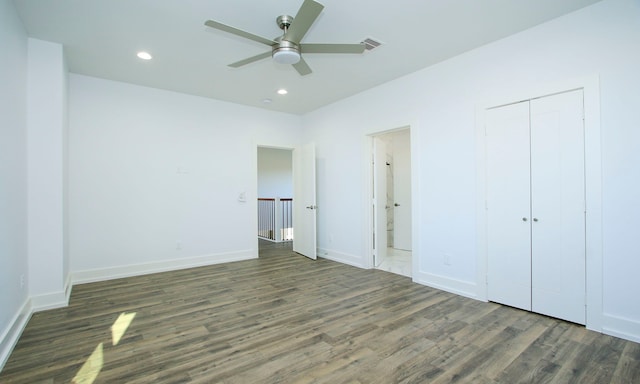 unfurnished bedroom with a closet, ceiling fan, dark hardwood / wood-style flooring, and ensuite bathroom