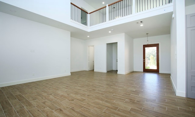 interior space featuring a towering ceiling and light hardwood / wood-style floors