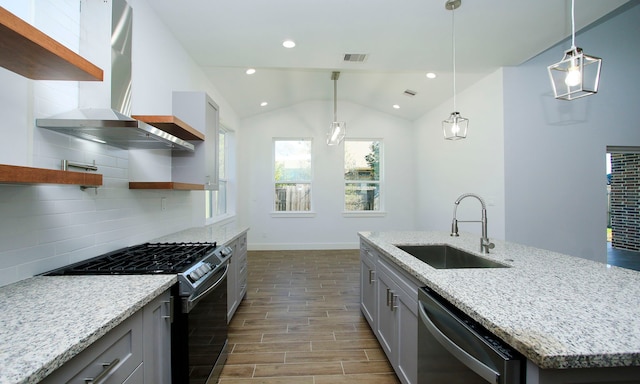 kitchen with sink, wall chimney exhaust hood, backsplash, vaulted ceiling, and appliances with stainless steel finishes