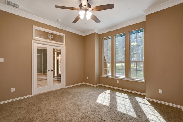 carpeted empty room featuring french doors, crown molding, a wealth of natural light, and ceiling fan