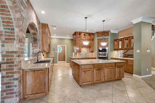 kitchen with a kitchen island, tasteful backsplash, sink, hanging light fixtures, and ornamental molding