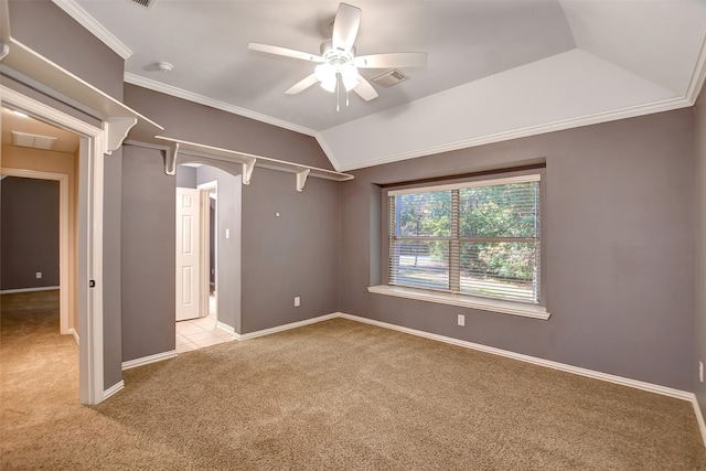 spare room with lofted ceiling, crown molding, ceiling fan, and light colored carpet