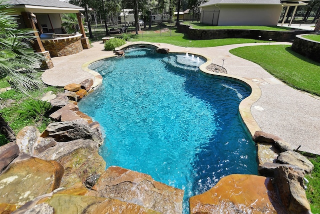 view of pool featuring a jacuzzi, a patio, and a yard