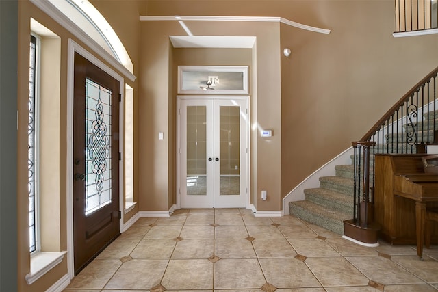 entrance foyer featuring ornamental molding, french doors, and light tile patterned flooring