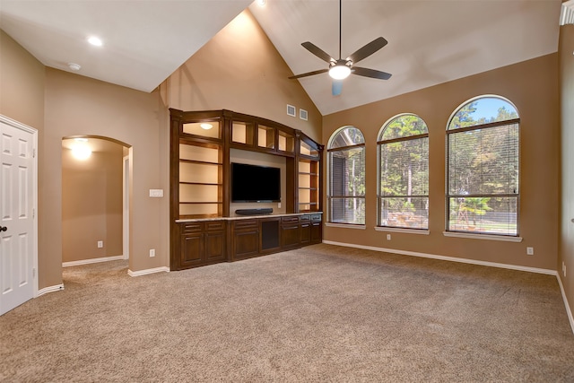 unfurnished living room featuring ceiling fan, carpet, and high vaulted ceiling