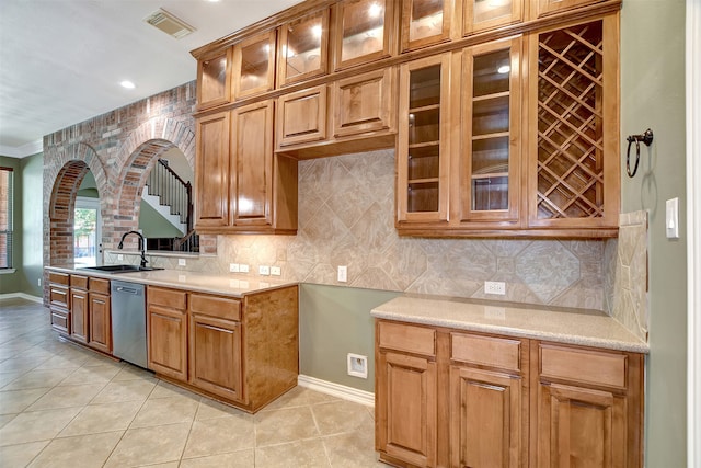 kitchen featuring light tile patterned flooring, sink, tasteful backsplash, stainless steel dishwasher, and crown molding