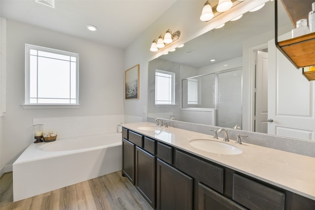 bathroom featuring vanity, shower with separate bathtub, wood-type flooring, and a healthy amount of sunlight