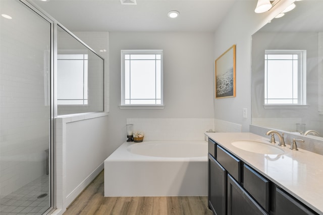 bathroom featuring vanity, plus walk in shower, hardwood / wood-style flooring, and a healthy amount of sunlight