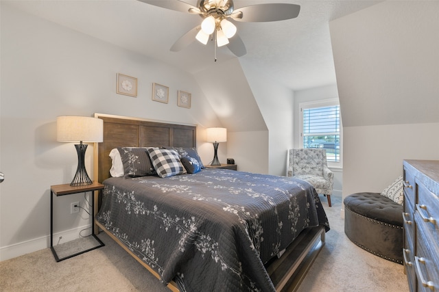 bedroom with ceiling fan, vaulted ceiling, and light colored carpet