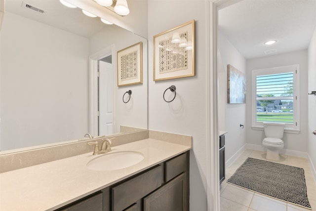 bathroom featuring toilet, vanity, and tile patterned flooring