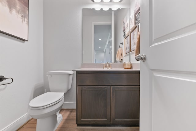 bathroom featuring vanity, hardwood / wood-style flooring, and toilet