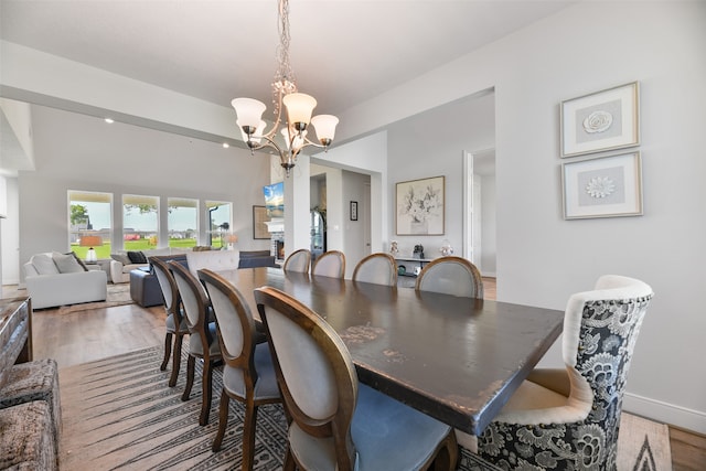 dining space with hardwood / wood-style flooring and a chandelier