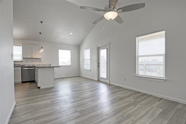 unfurnished living room with lofted ceiling, light hardwood / wood-style flooring, a textured ceiling, and ceiling fan