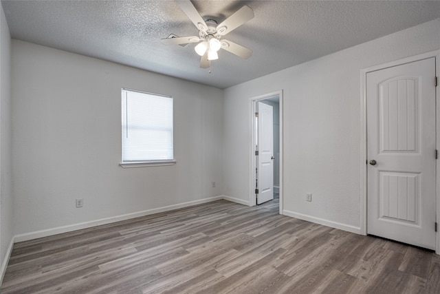 unfurnished room with light hardwood / wood-style flooring, a textured ceiling, and ceiling fan