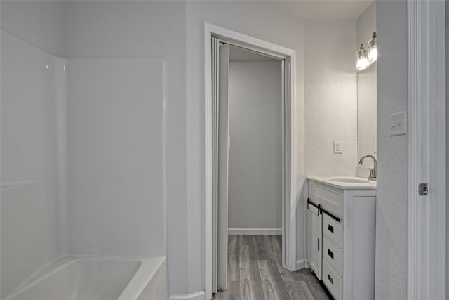 bathroom with vanity, washtub / shower combination, and wood-type flooring