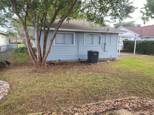 rear view of house featuring a lawn and cooling unit