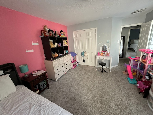 carpeted bedroom featuring a textured ceiling and a closet