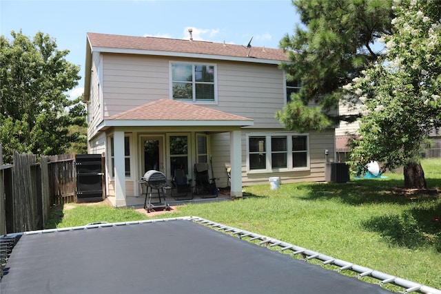 back of property with a lawn, a patio, and central air condition unit