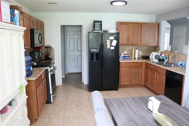 kitchen featuring black appliances, sink, light tile patterned floors, and backsplash