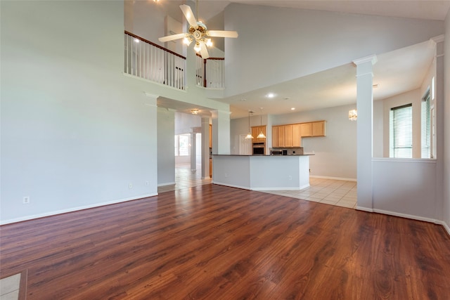 unfurnished living room featuring high vaulted ceiling, light hardwood / wood-style flooring, and plenty of natural light