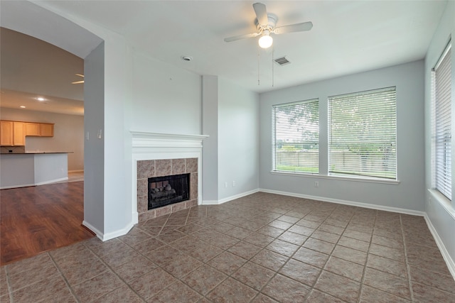 unfurnished living room featuring tile patterned floors, a fireplace, and ceiling fan