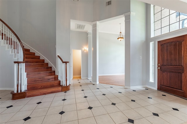 entrance foyer with ornate columns and a high ceiling