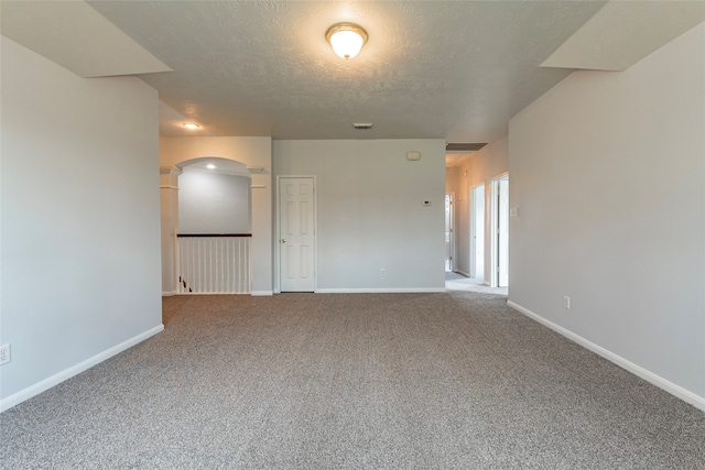 carpeted empty room with a textured ceiling