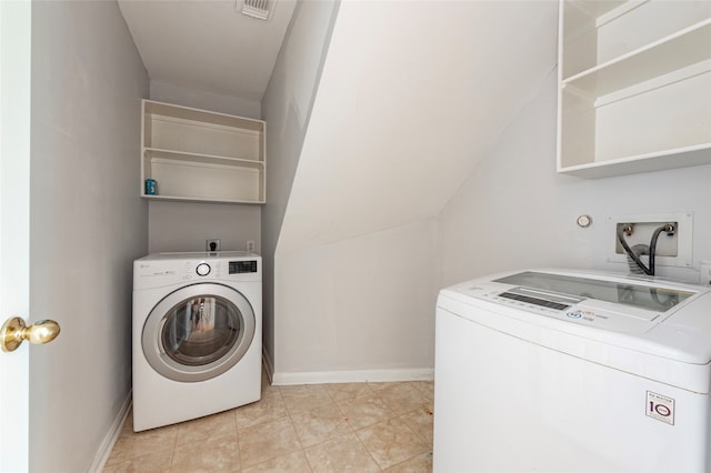 laundry room with separate washer and dryer and light tile patterned floors