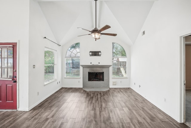 unfurnished living room with hardwood / wood-style floors, high vaulted ceiling, and ceiling fan