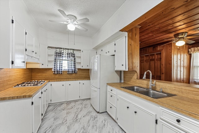 kitchen featuring ceiling fan, sink, and white cabinetry