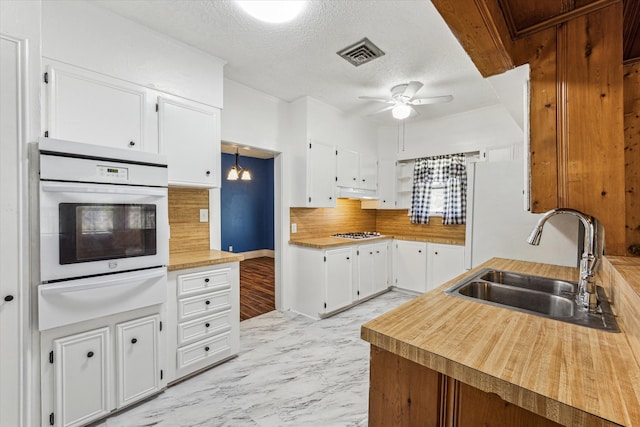 kitchen featuring ceiling fan, sink, a textured ceiling, white cabinetry, and white oven