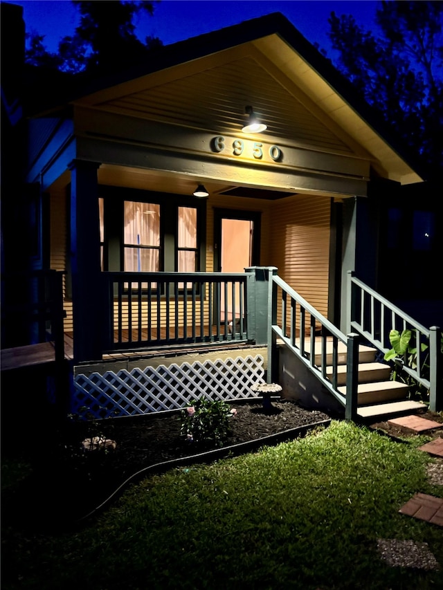 exterior entry at night featuring covered porch