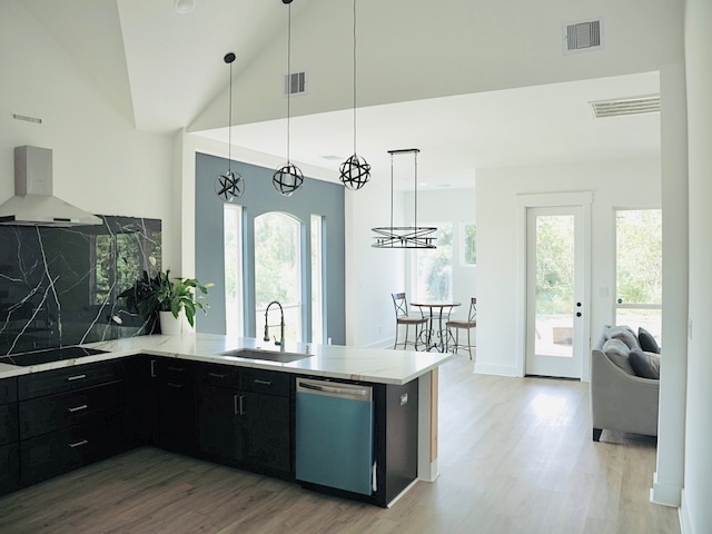 kitchen with decorative light fixtures, dishwasher, wall chimney exhaust hood, and kitchen peninsula