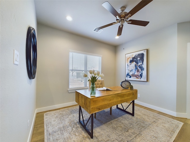 home office with wood-type flooring and ceiling fan