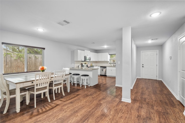 dining room with dark hardwood / wood-style flooring and plenty of natural light