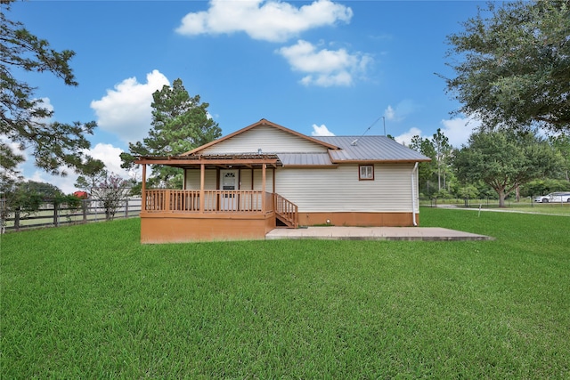 rear view of property featuring a lawn and a deck